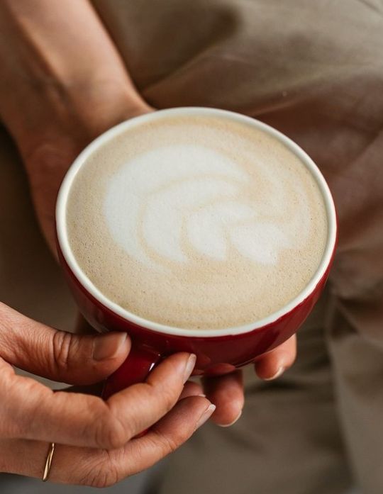 Pantastic manos sujetando taza roja de cafe
